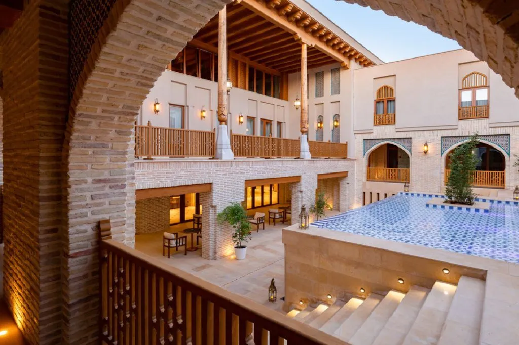 Traditional Uzbek courtyard hotel with pool at dusk