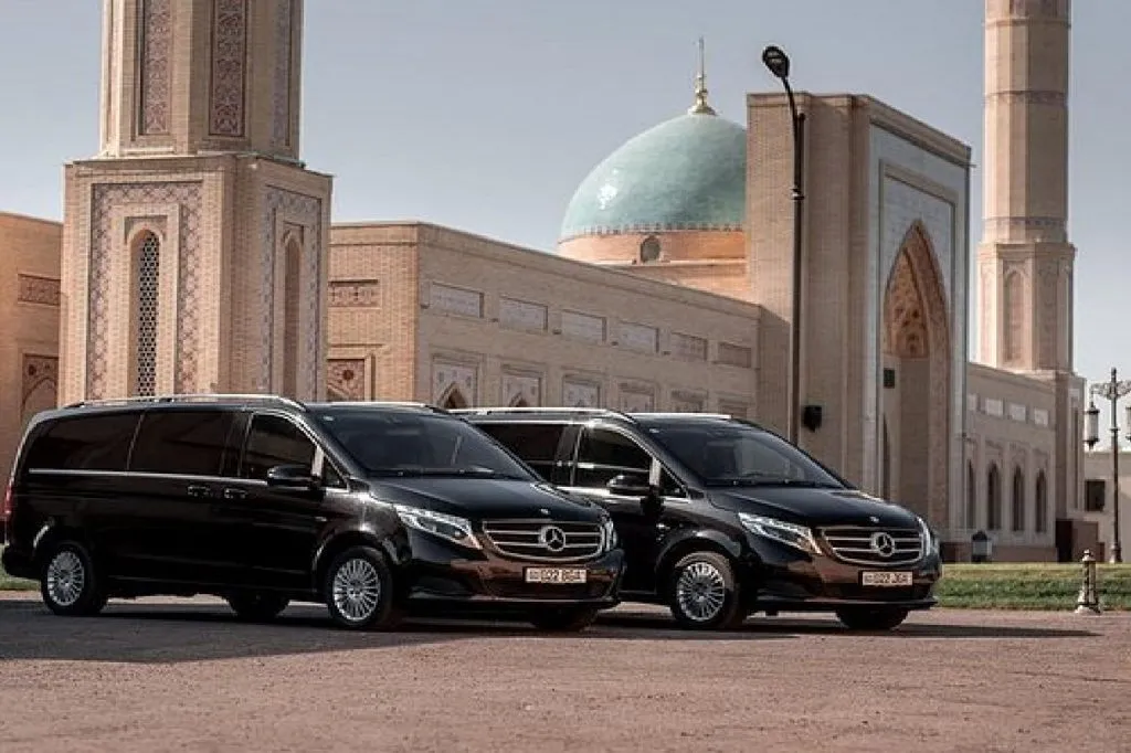 Private transfer vehicles in front of a mosque in Uzbekistan
